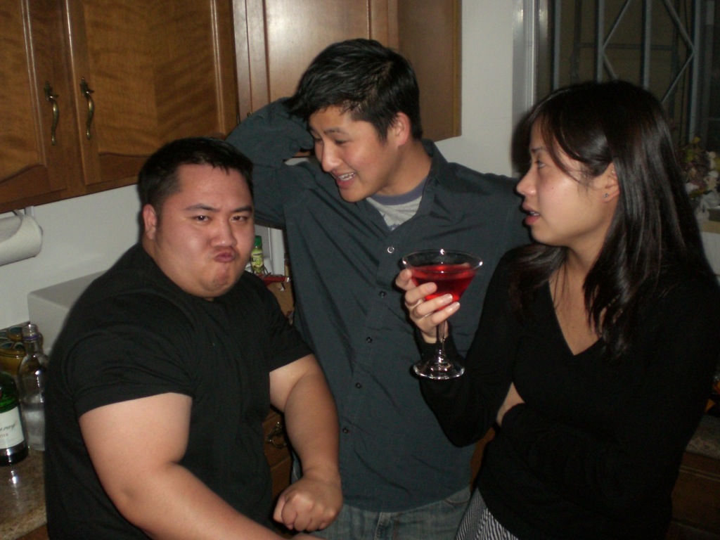 there are four people standing together drinking wine