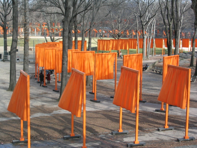orange wooden poles with people in the background
