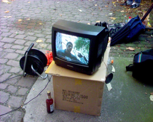 a television set is on top of a box near a garbage can