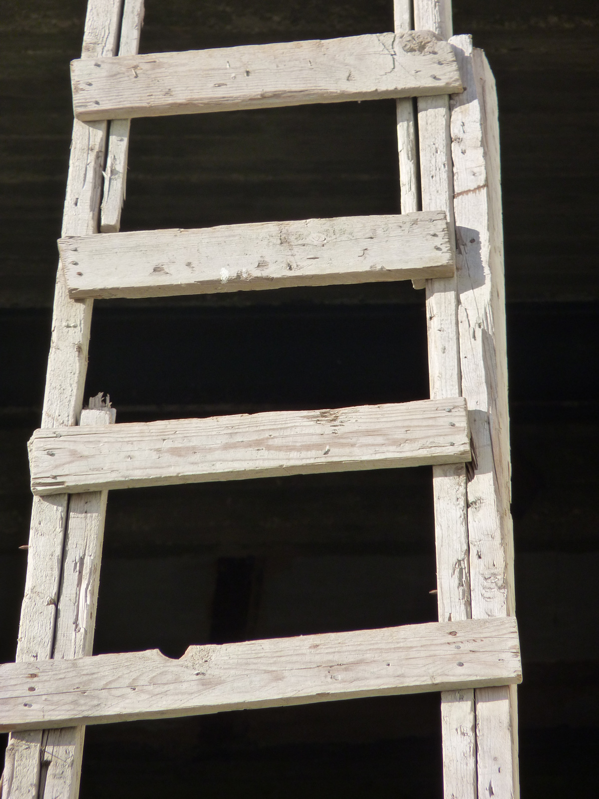 old ladder showing two layers, painted white
