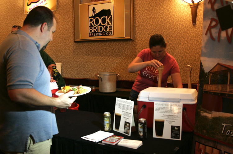 a man holding a plate of food with another man in the background