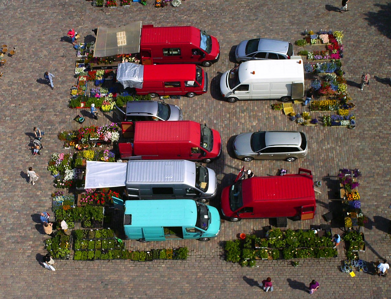 overhead view of parked cars on brick pavement