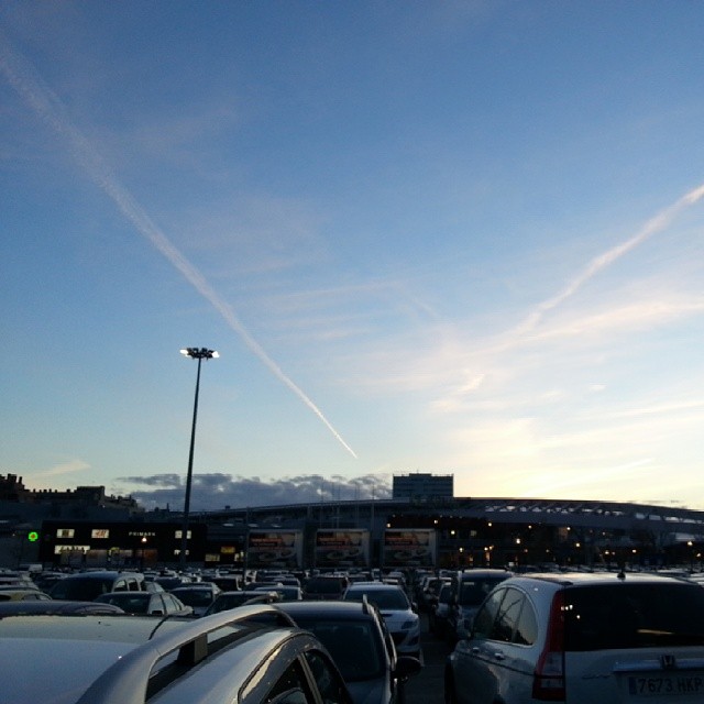 an airport with a jet contrail in the sky