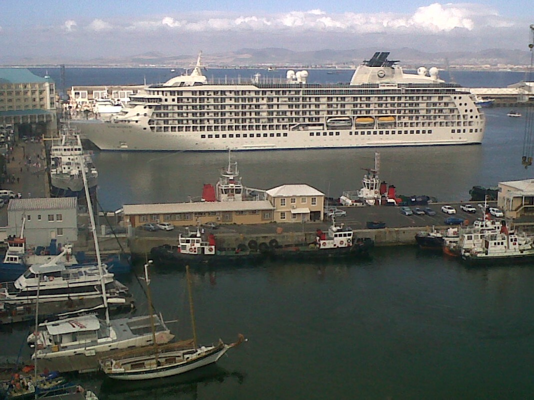 a large ship is in the water next to small boats