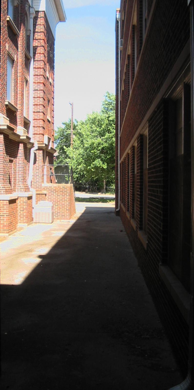 a sidewalk in an alley with no people