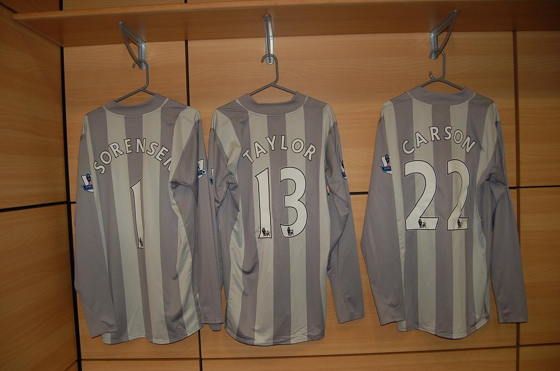 two soccer shirts sitting next to each other hanging