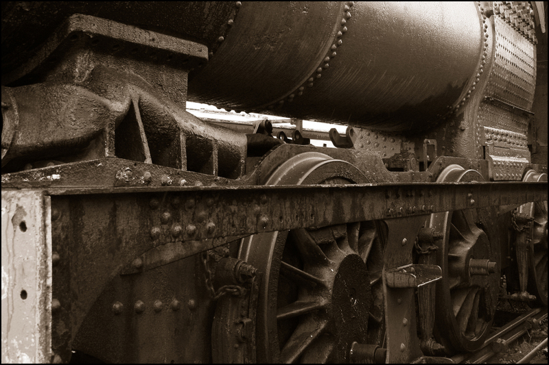 an old and rusty locomotive sits still in the dark