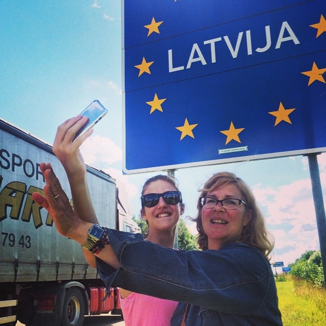 two women taking pictures in front of a star sign and truck