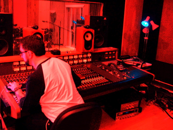 a man is sitting at a table in a recording studio
