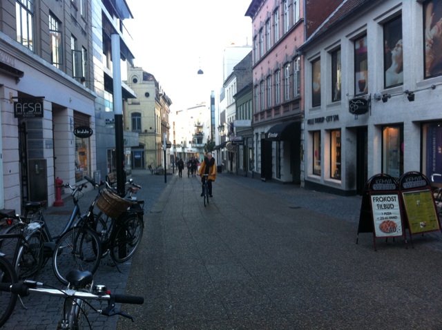several people ride their bikes down the city street
