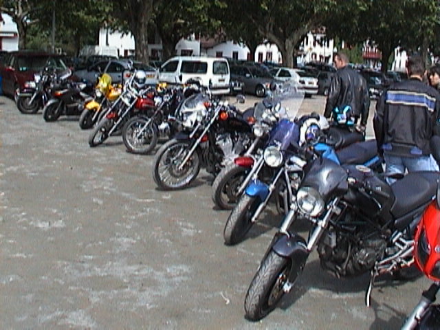 motorcycles parked outside of some buildings in front of people