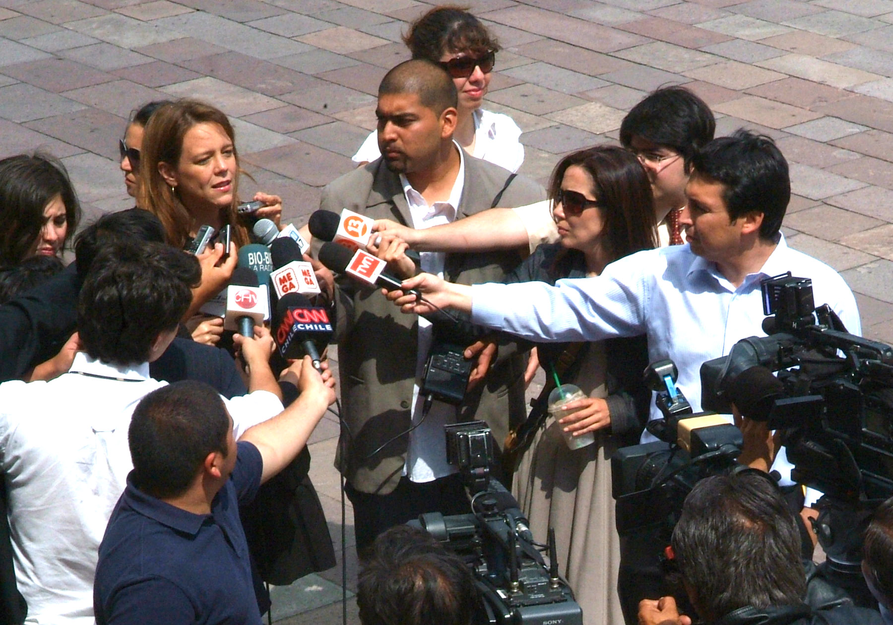 many people are standing around some microphones on the street