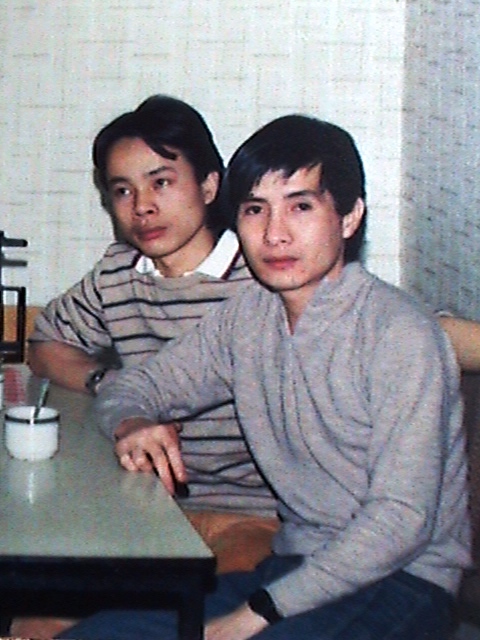 two young men are sitting at a table together