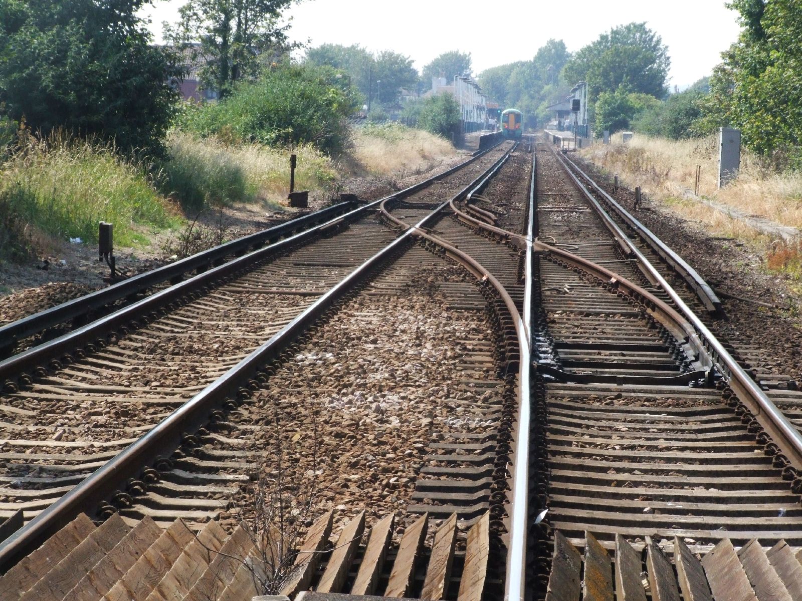 an empty railway track running through a rural area