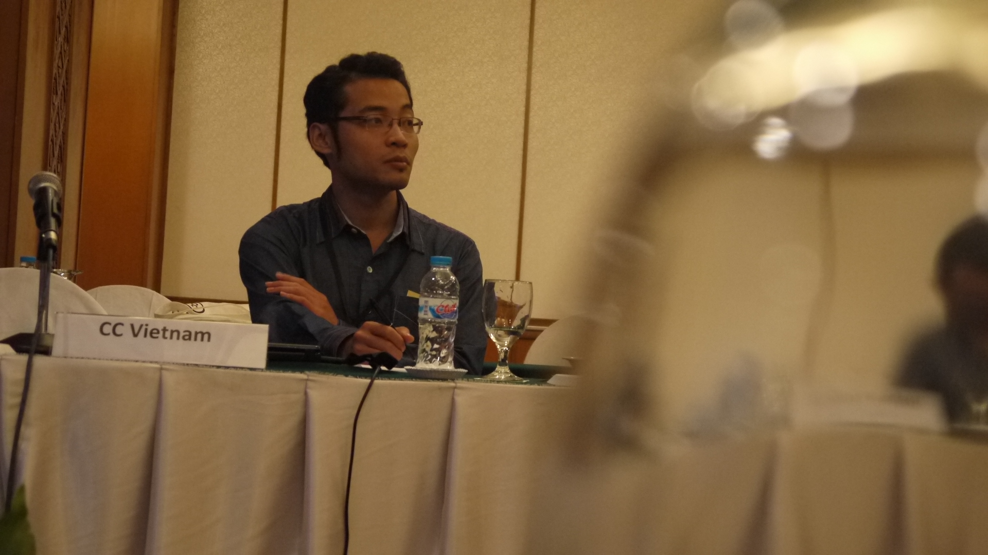 man in black shirt speaking at conference table