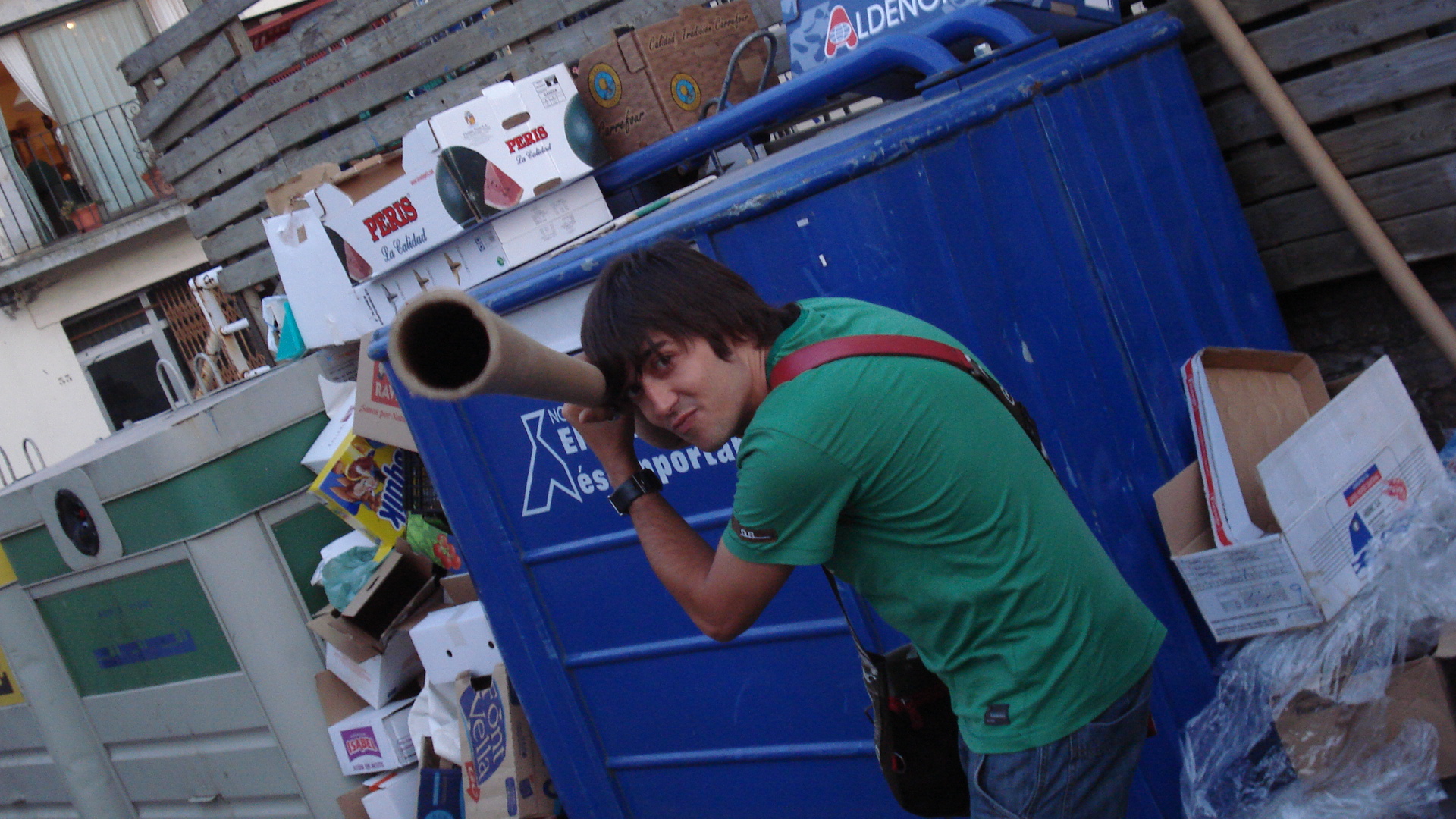 a young man with a speaker standing by some dump
