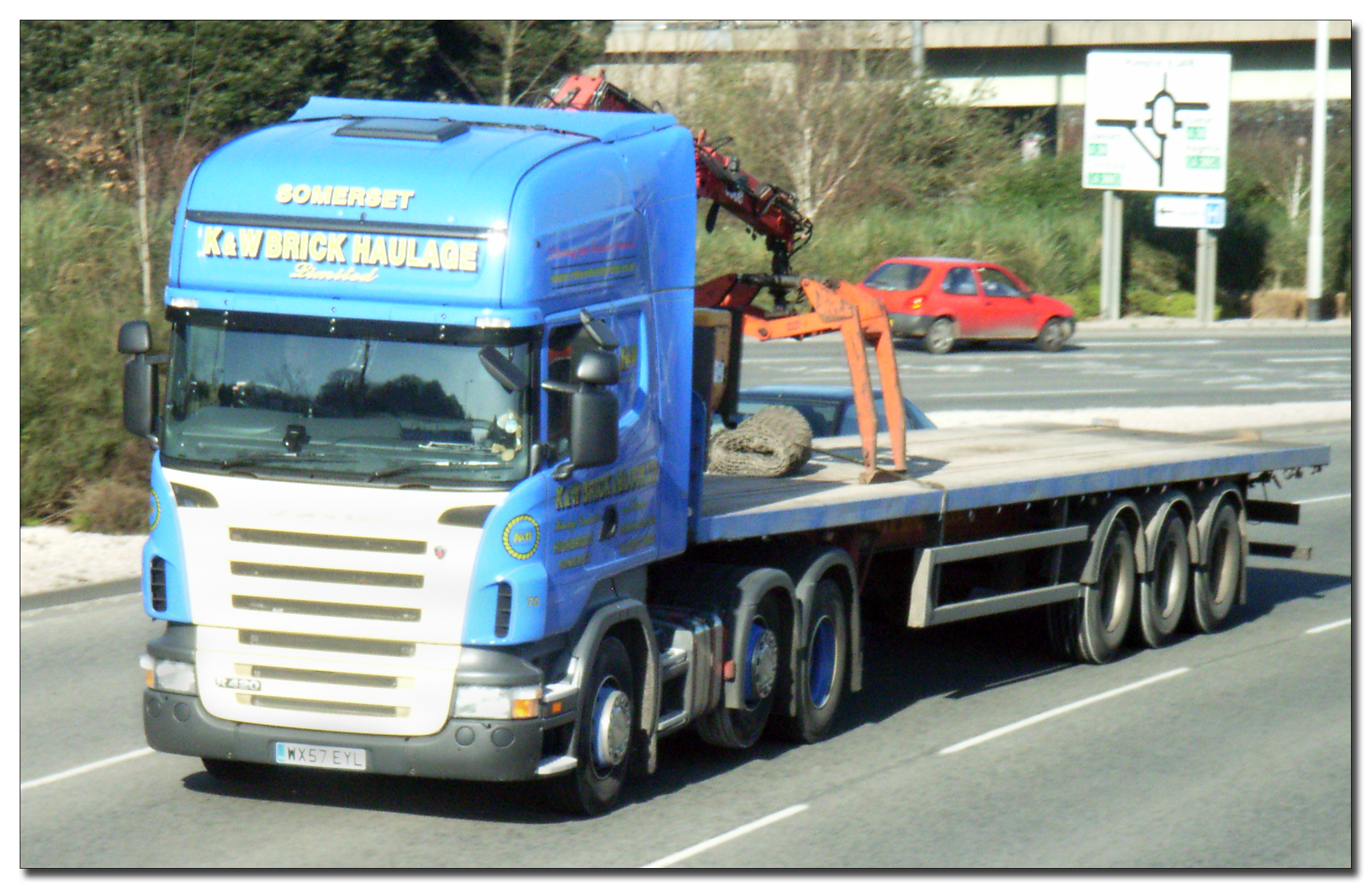 a truck traveling down a city road past parked cars