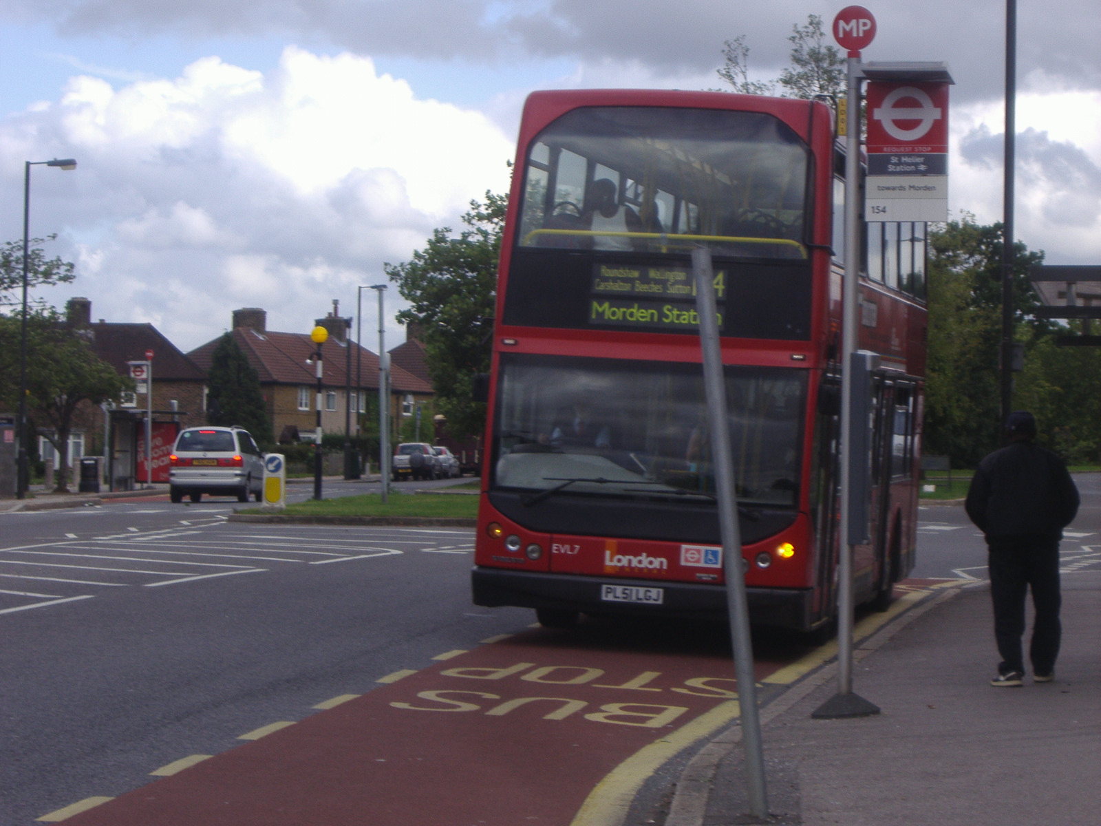 a double decker bus is pulling up to a bus stop