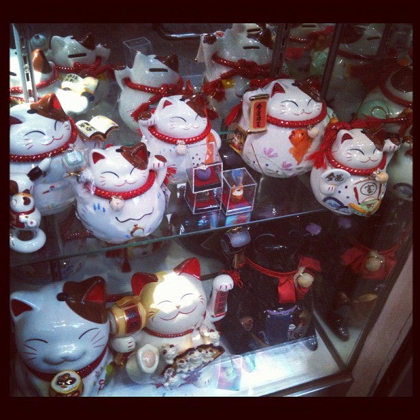 an assortment of mugs and cat teapots on display
