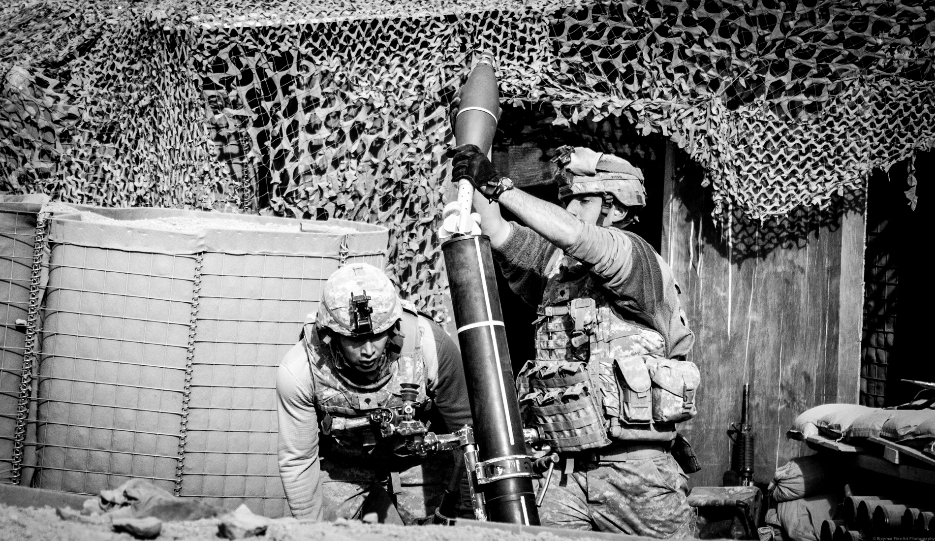 the two soldiers are standing in front of their weapons