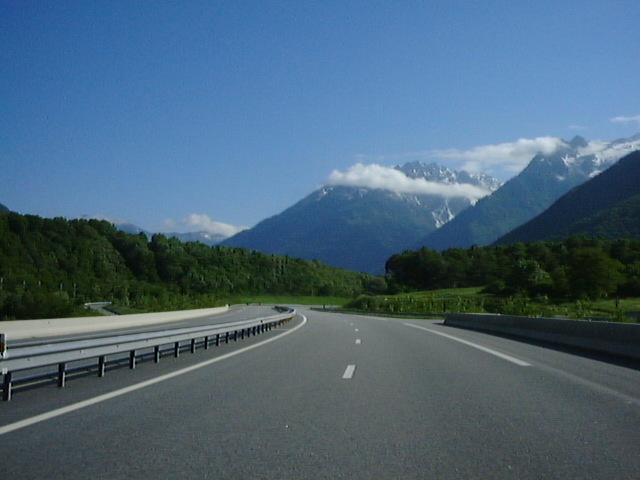 the highway is empty and has some vehicles driving on it