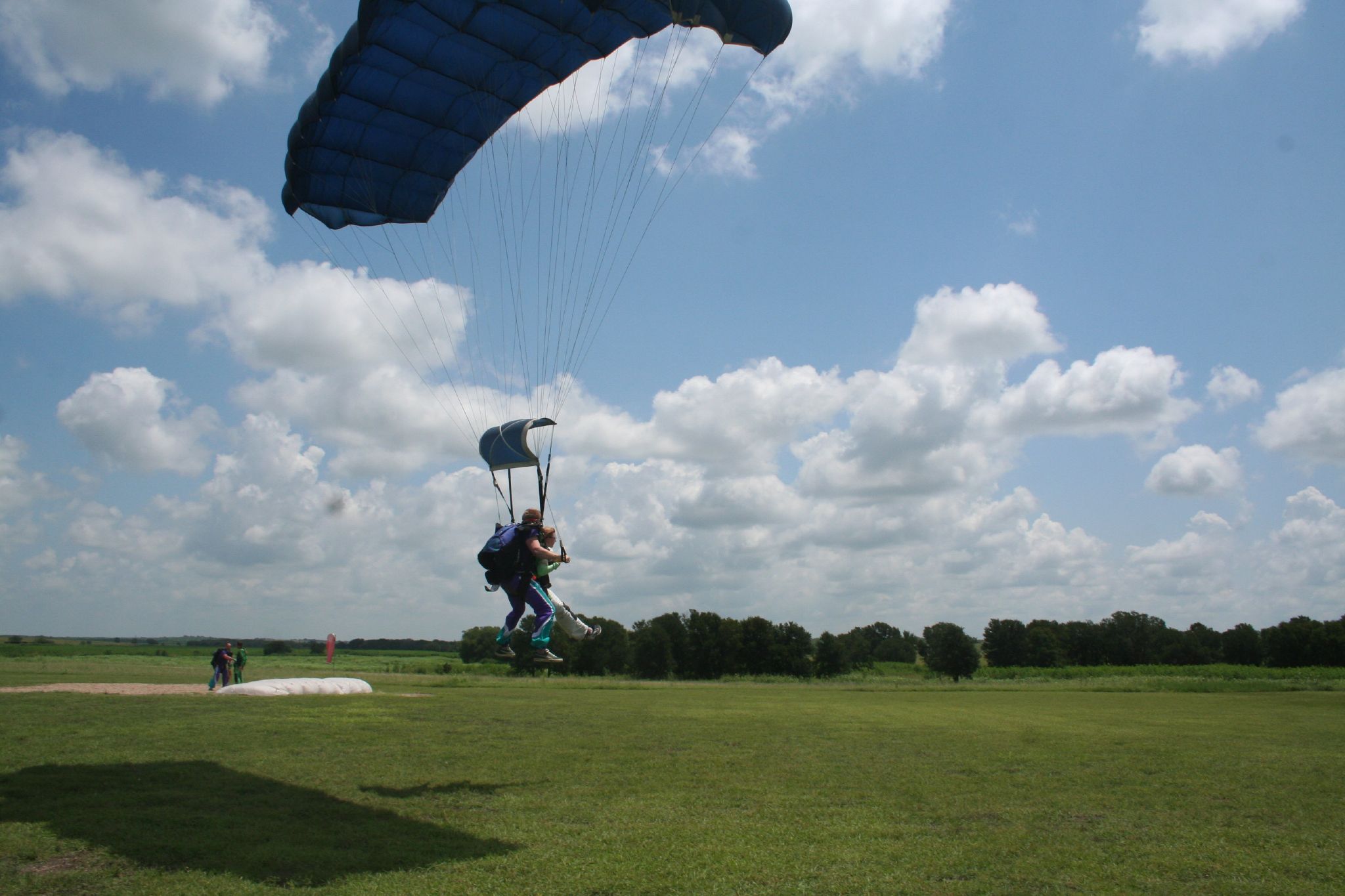 two people on a field are parasailing