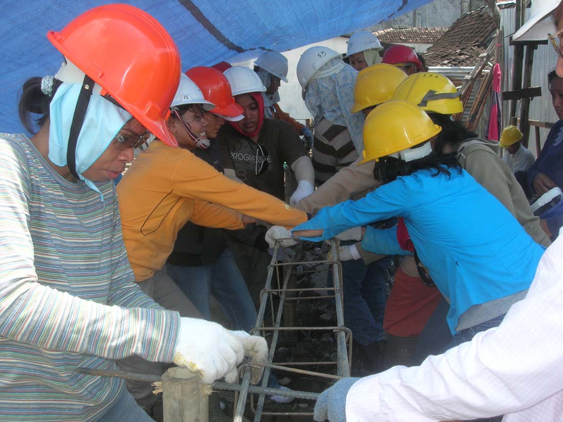 people wearing hard hats are lined up on the side of a ladder