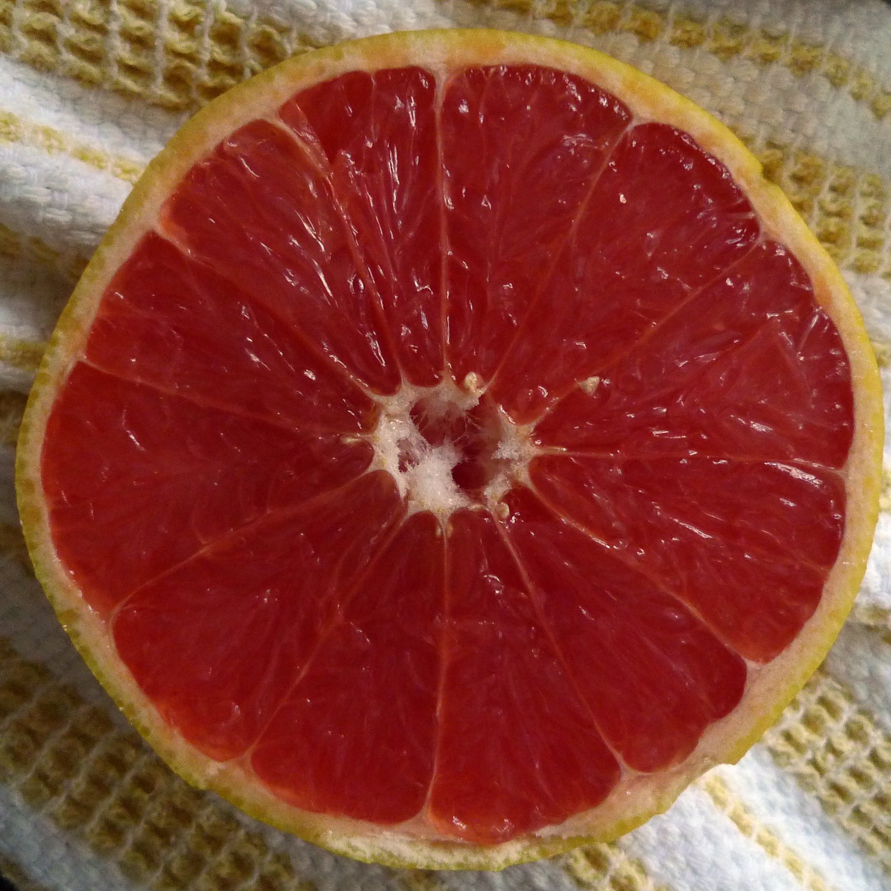 a  orange cut in half on a yellow towel