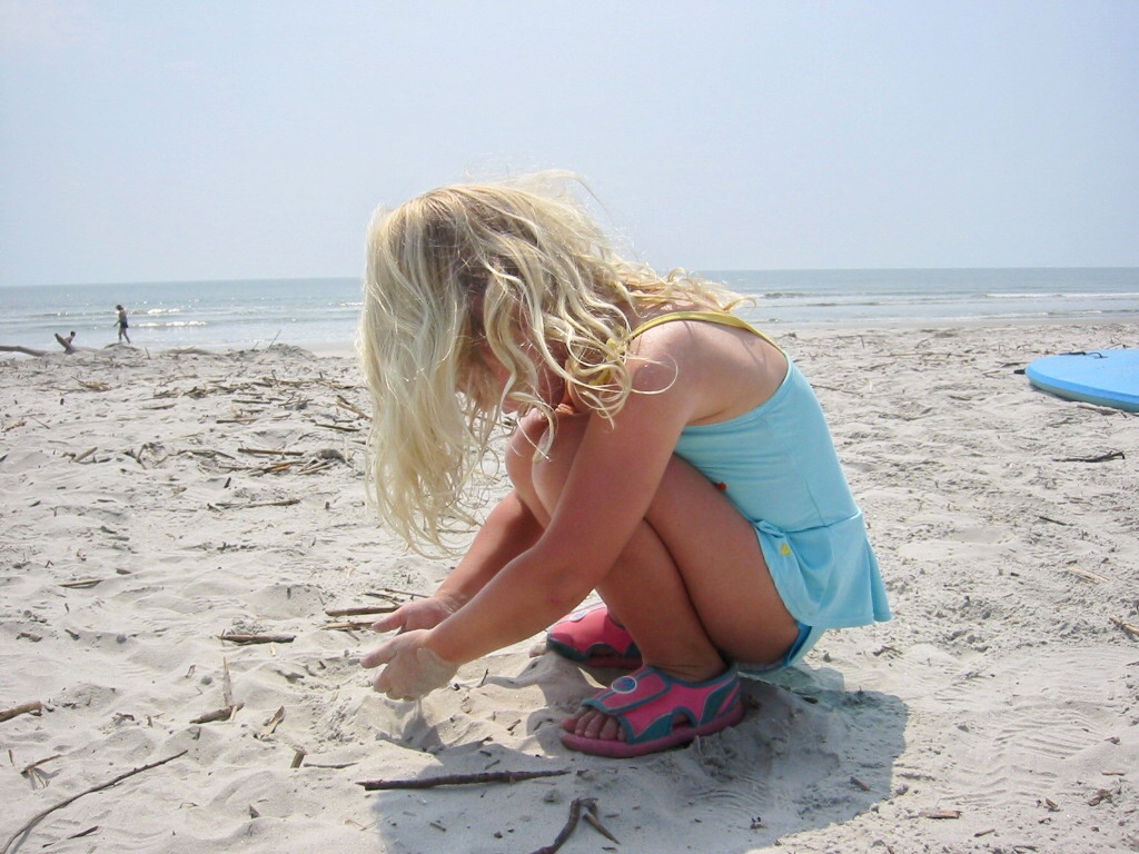 there is a little girl playing with a toy at the beach