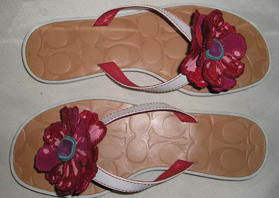 pair of girls pink sandals with a flower on the side