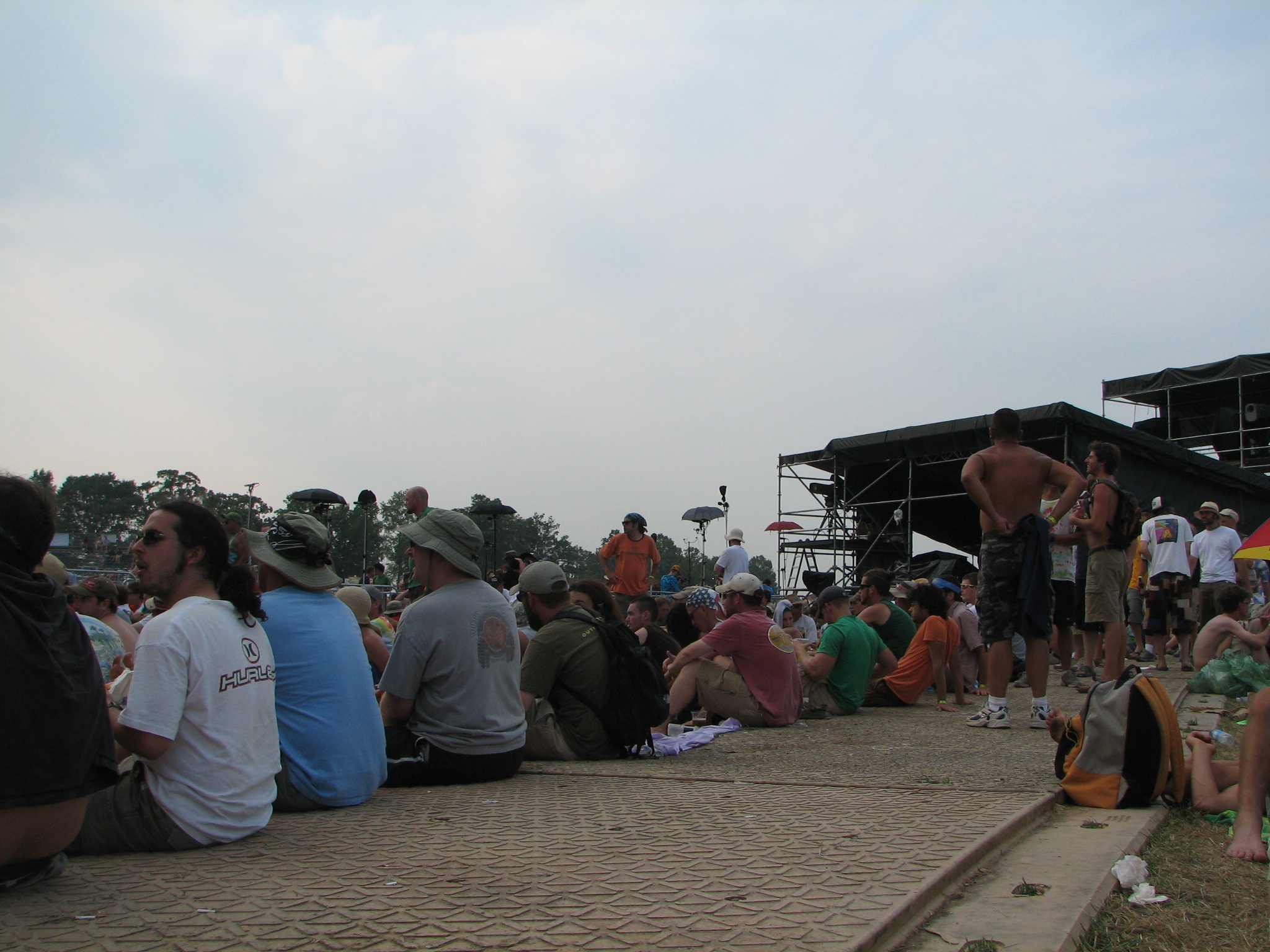 a group of people sitting on the ground watching people perform