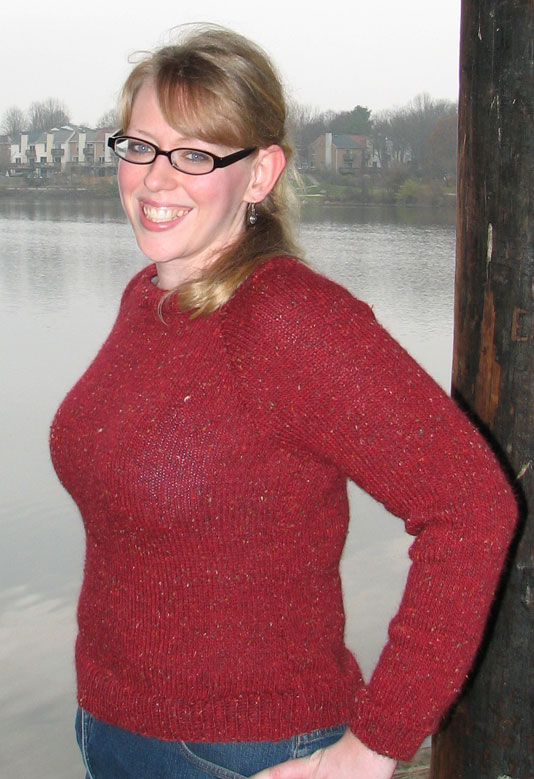a woman with glasses standing in front of water