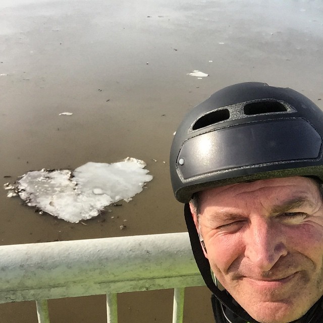 an older man wearing a helmet on top of a bike