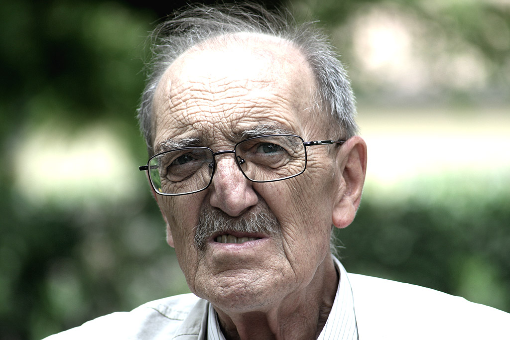 an older man wearing glasses and a tie