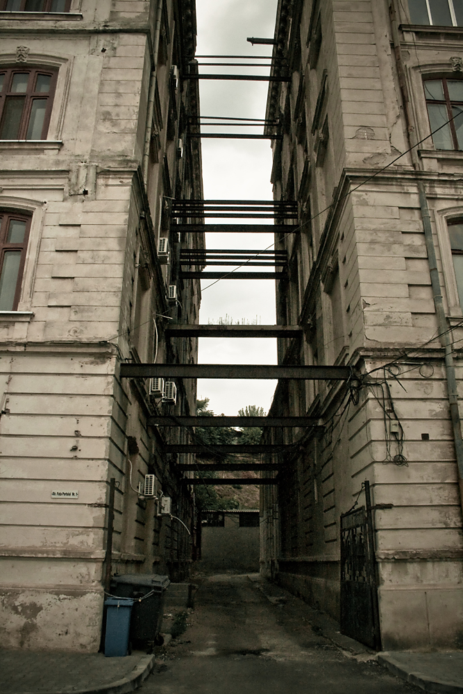 an empty alley leading into a tall building