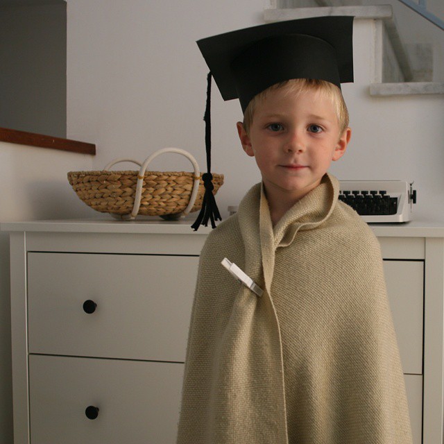 a boy in a graduation cap and robe
