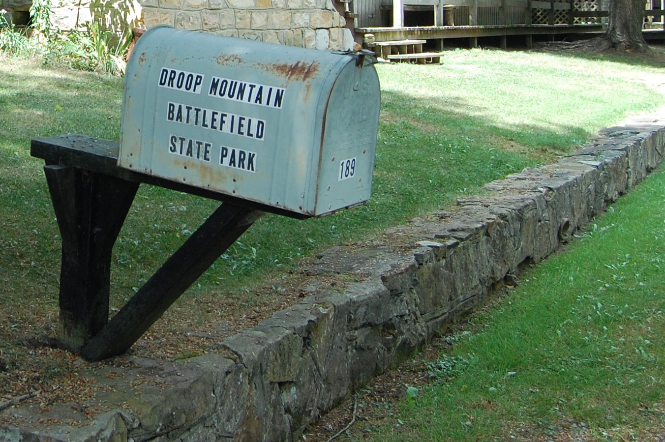 a mail box is placed on the curb by the grass