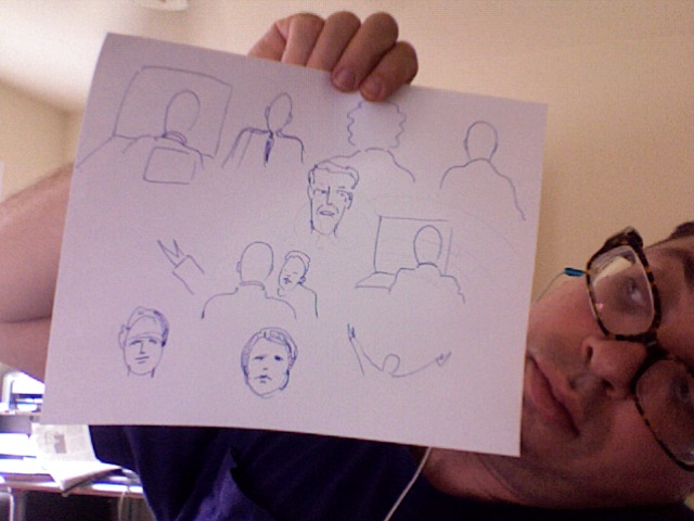 a man holding up a paper with sketches of faces drawn on it