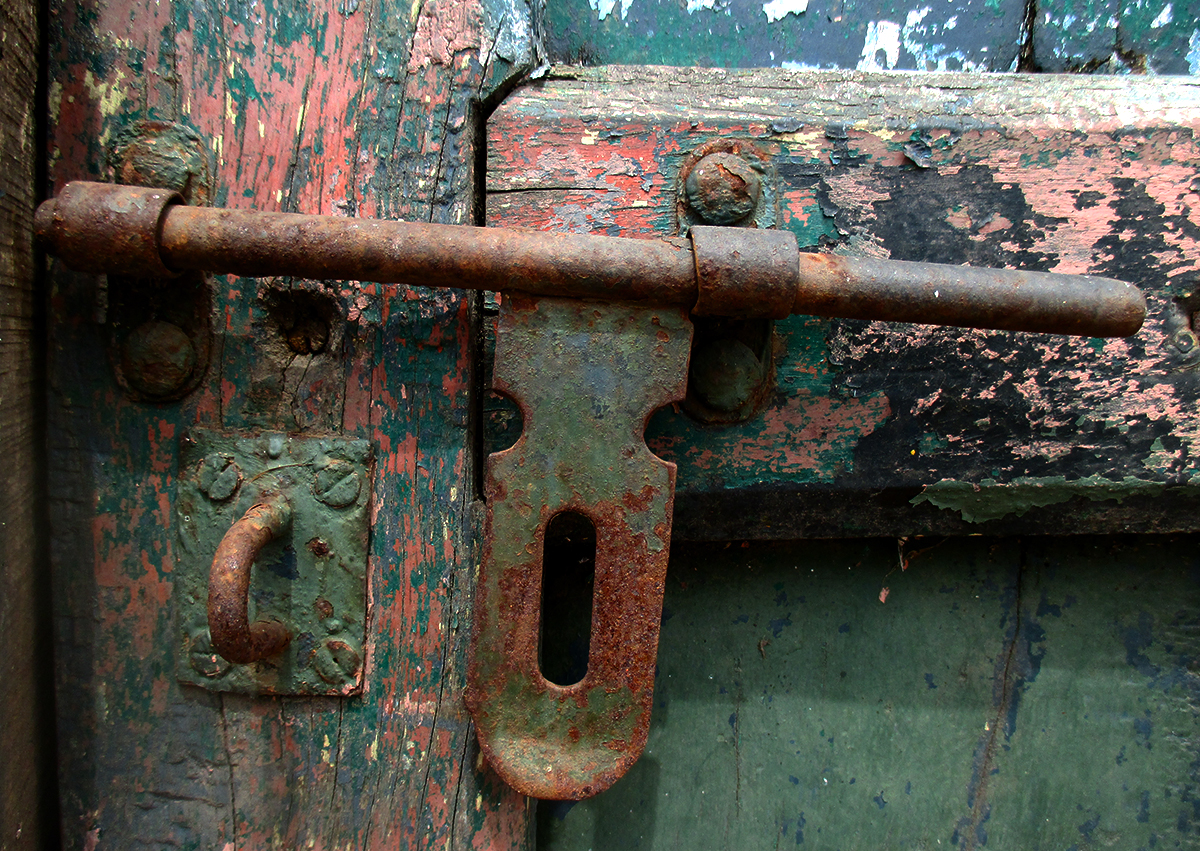 a rusted latch is on the old door