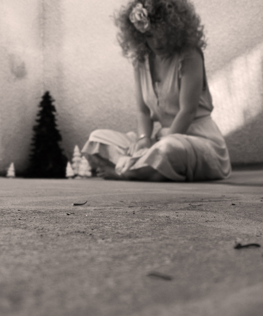 a woman sits on the floor with her feet crossed