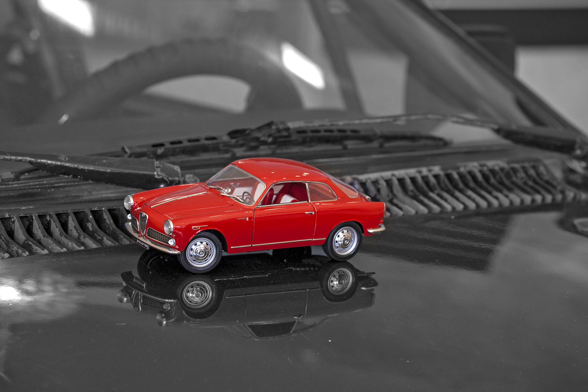 a red classic car sitting on top of a black surface