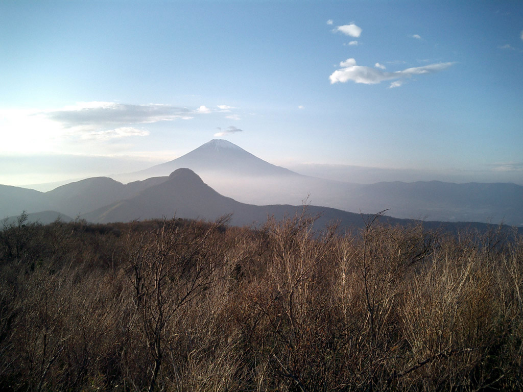 a large mountain covered in clouds and vegetation