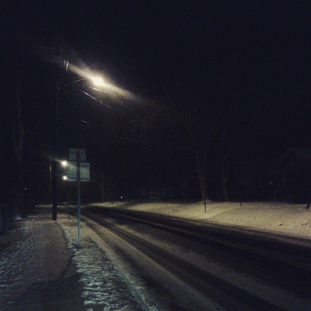 a dark street with some snow on it