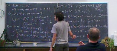 two men in front of a blackboard are talking