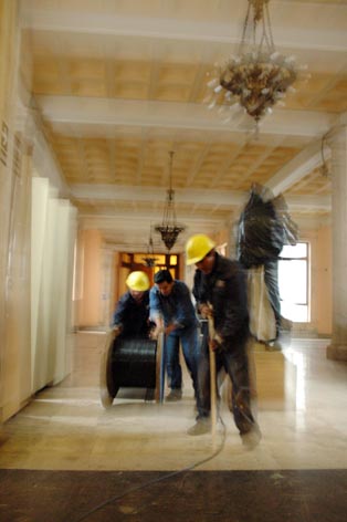 two men on a marble floor are working in an old style house