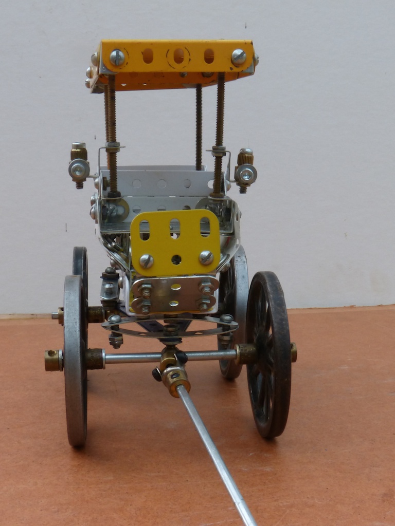 a metal and metal vehicle made from wire with yellow wheels