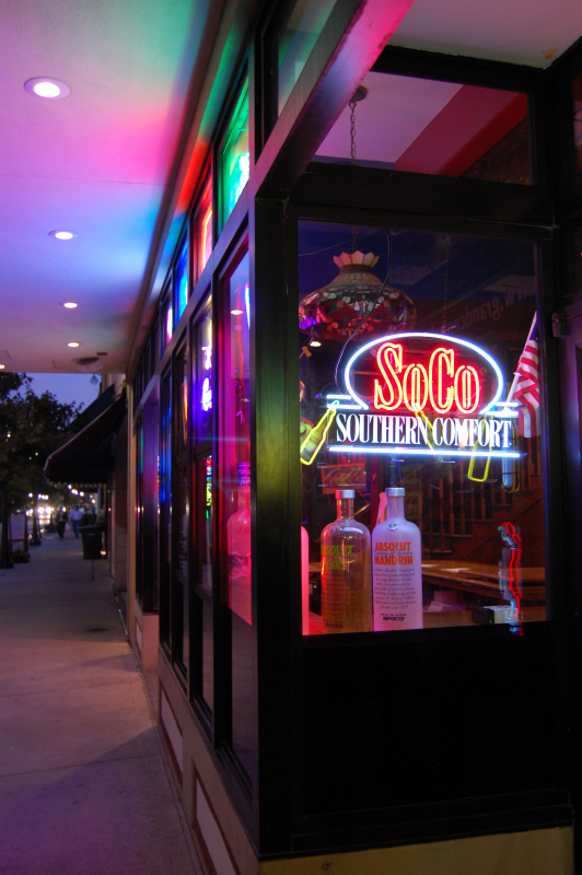 neon lights shining on the windows of a building