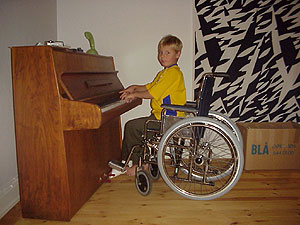 a  in a wheelchair playing piano