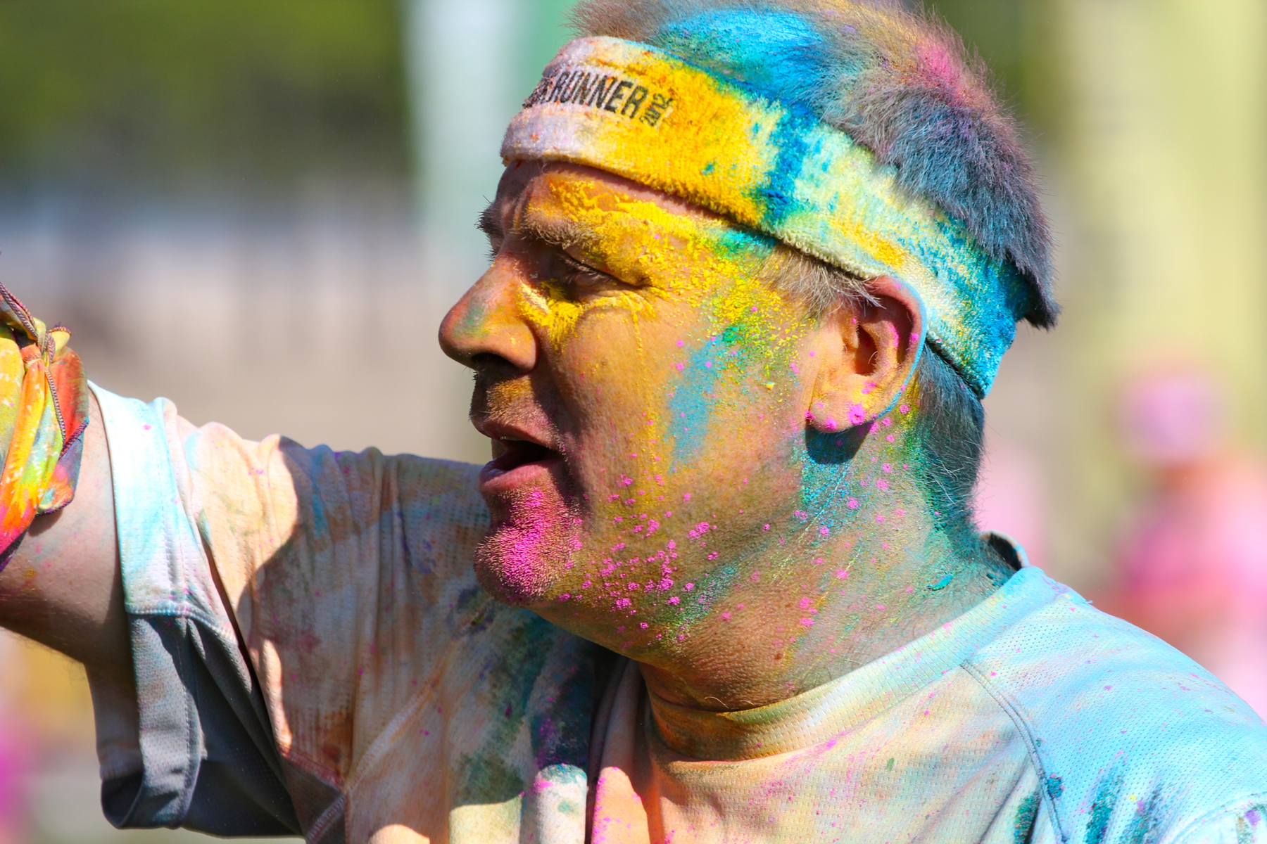 a man with his hand on his hip is wearing colorful paint