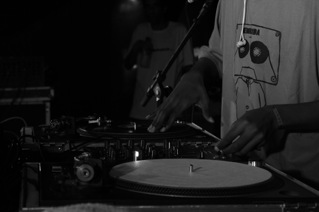 black and white pograph of dj spinning the turntable at an event